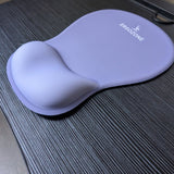 Tapis de souris ergonomique Ergozone lavande avec repose-poignet, posé sur un bureau