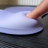 Doigt qui appuie sur le repose-poignet en mousse du tapis Ergozone lavande
