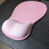 Tapis de souris ergonomique Ergozone rose avec repose-poignet, posé sur un bureau