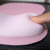 Doigt qui appuie sur le repose-poignet en mousse du tapis Ergozone rose